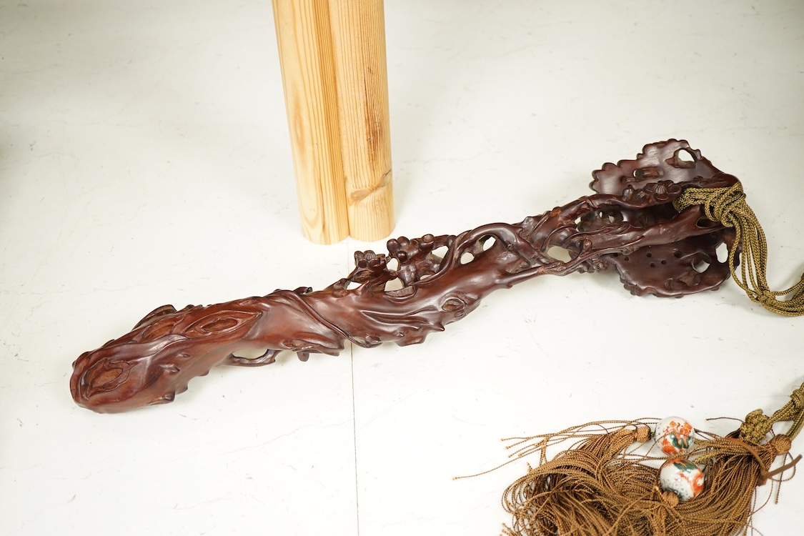 A Chinese carved hardwood Ruyi sceptre, with two porcelain ‘dragon’ beads, 50cm in length